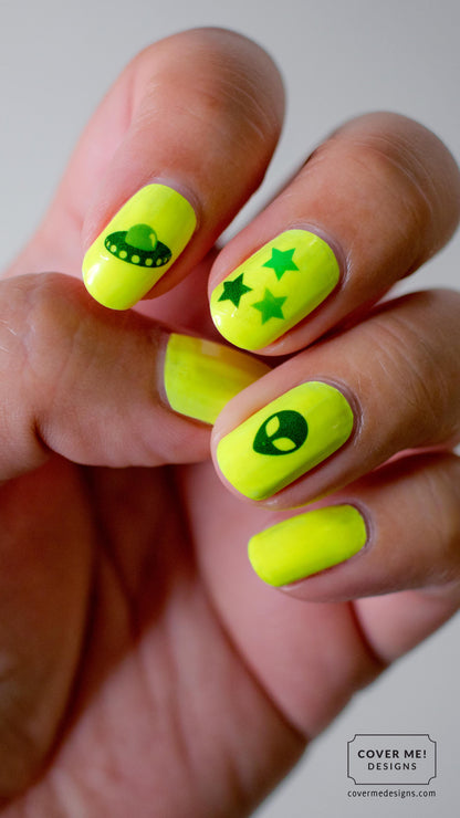 Neon yellow nail polish with UFO, alien, and star nail stickers