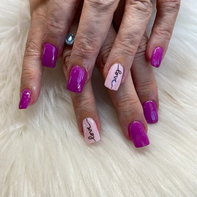 Dip Manicure with pink nail polish and the word "love" written on the ring finger