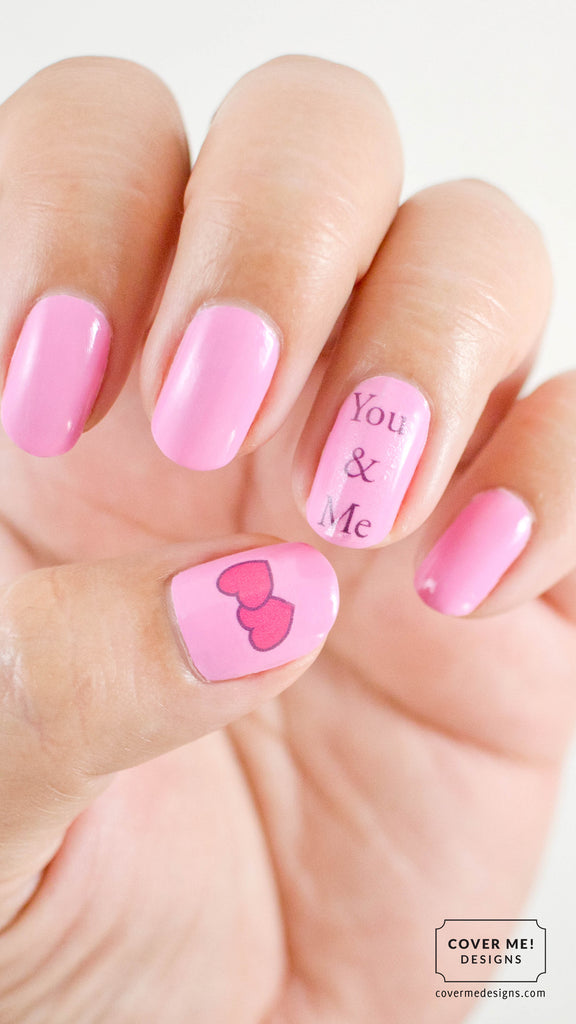 Wedding nail art with hearts and text that says "You and Me" on pink nail polish